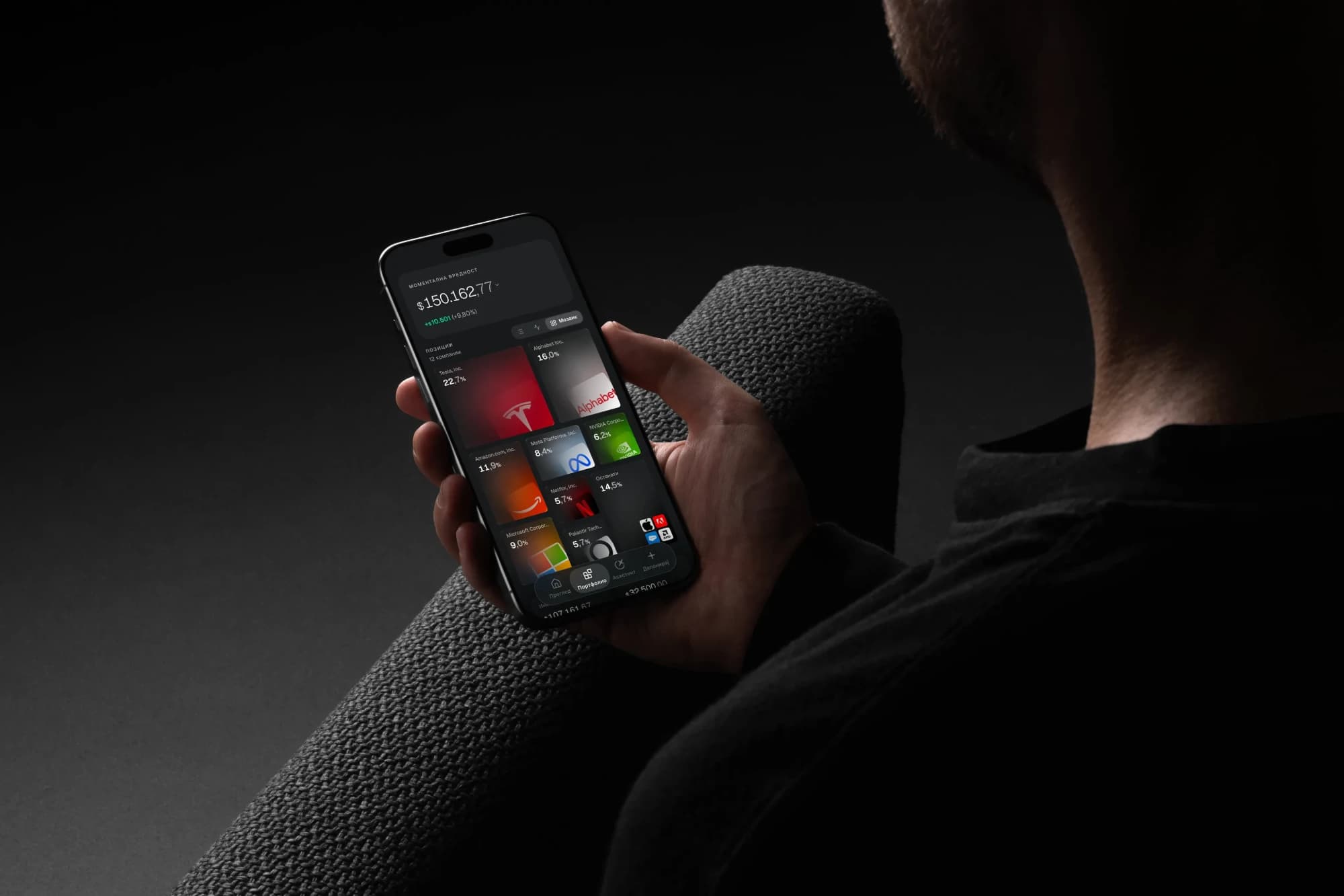 Телефон во рака со апликацијата Prime Signature, со портфолиото прикажано како мозаик